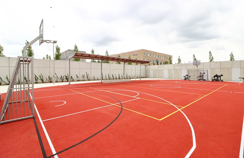 Het buitensportterrein tussen de betonnen muren