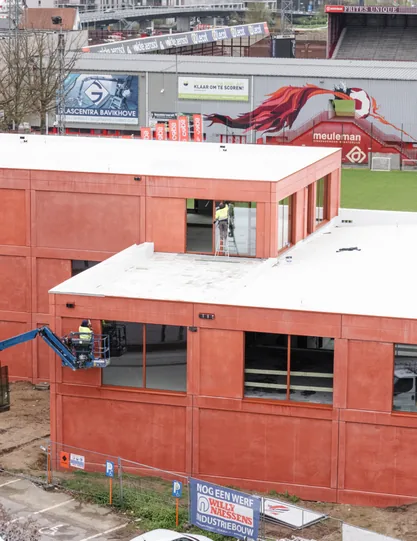 Het gebouw langs de invalsweg, met het stadion op de achtergrond