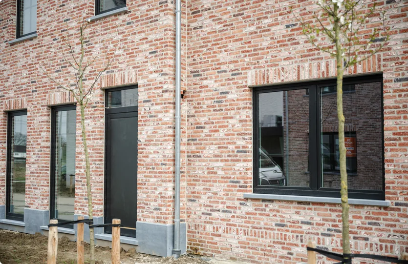 Woning in rood metselwerk met zwart aluminium schrijnwerk