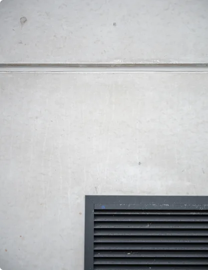 Afgewerkte voeg boven een verluchtingsrooster in de betonwand