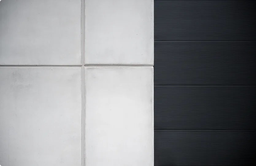 Kruising van vier betonpanelen naast een zwarte gevelplaat
