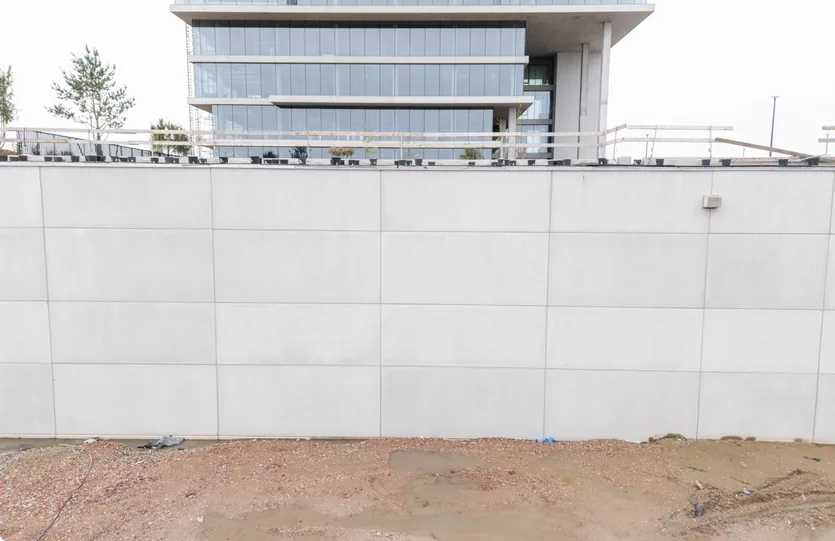 Keermuur in wit zichtbeton voor het gebouw